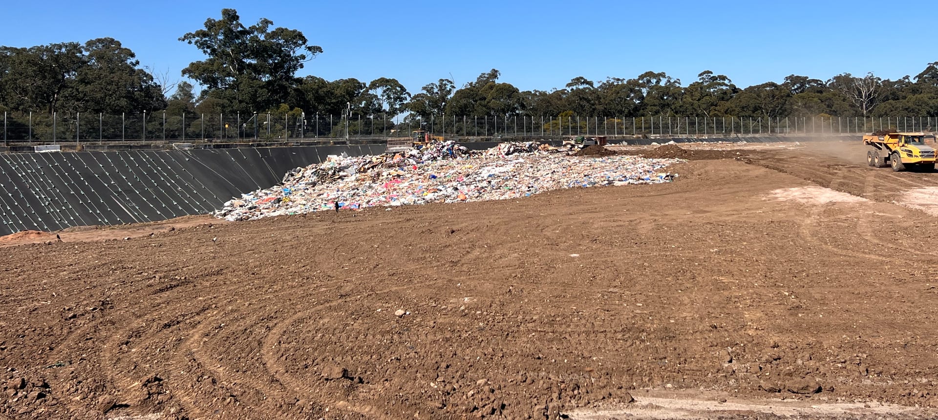 The working tip face at Glenfield Waste Services, with a haul truck on the floor of the lined cell and the tipping face behind.