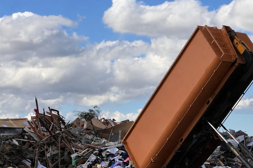 A hook-lift truck tipping a bin of mixed waste at the face at Glenfield Waste Services.
